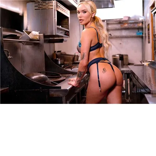 Blonde female posed in kitchen wearing lingerie displaying rear