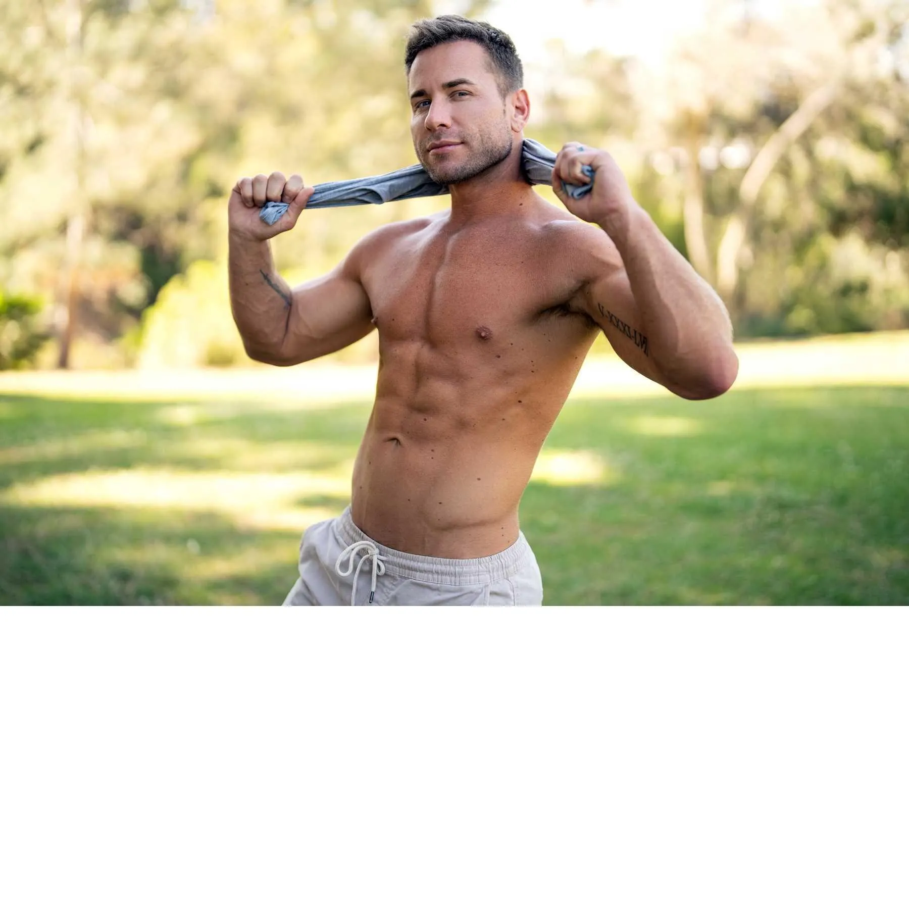 Male posed topless outdoors displaying abs