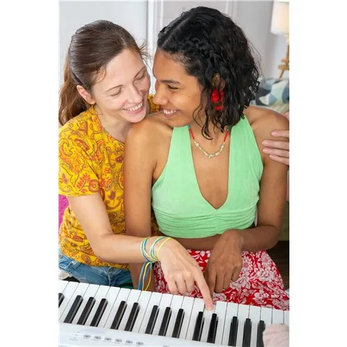 Two brunette females sitting at keyboard