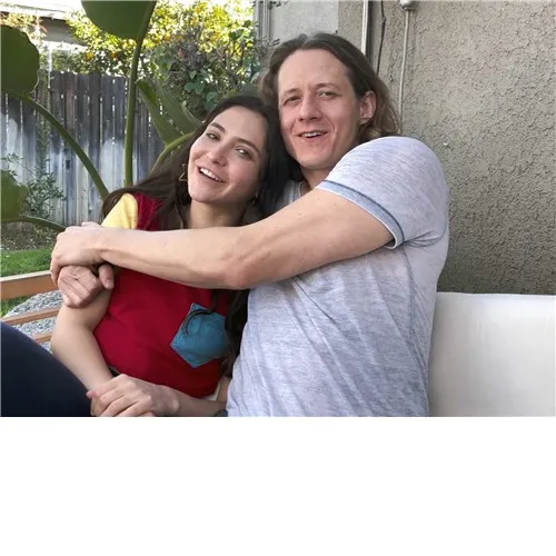 Clothed male and female sitting on couch