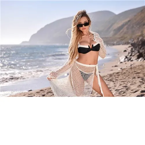 Blonde female posed wearing lingerie on beach displaying cleavage