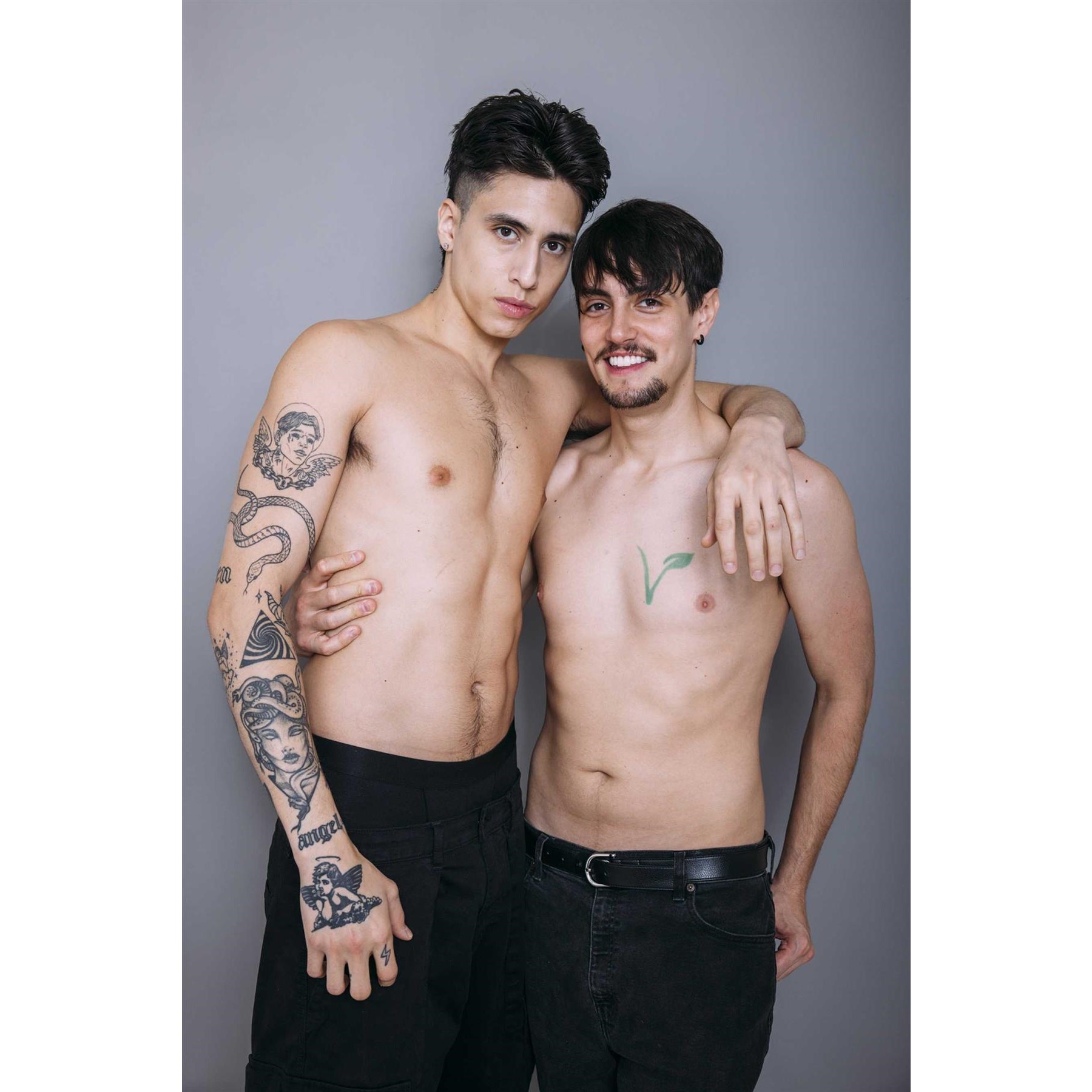 Two male posed topless displaying abs